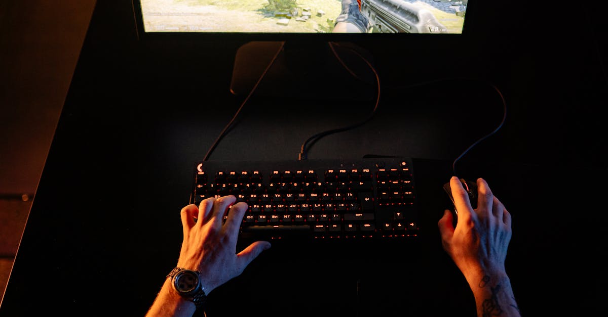 A gamer intensely playing a first-person shooter game on a computer setup indoors at night.