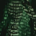An unrecognizable person with binary code projected, symbolizing cybersecurity and digital coding.