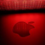 Artistic photo of a glowing apple-shaped graphic with a checkered pattern and red background.