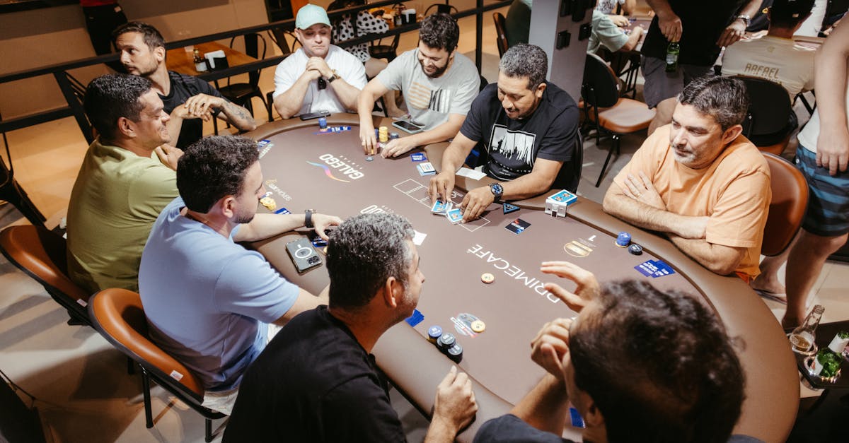 Group of men engaged in a poker game at an indoor setting, showcasing social interaction.