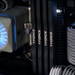 Detailed close-up of a computer cooling system featuring T-FORCE components and blue lighting.