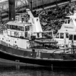 A classic black and white photo of a tugboat docked in Saint-Malo harbor.