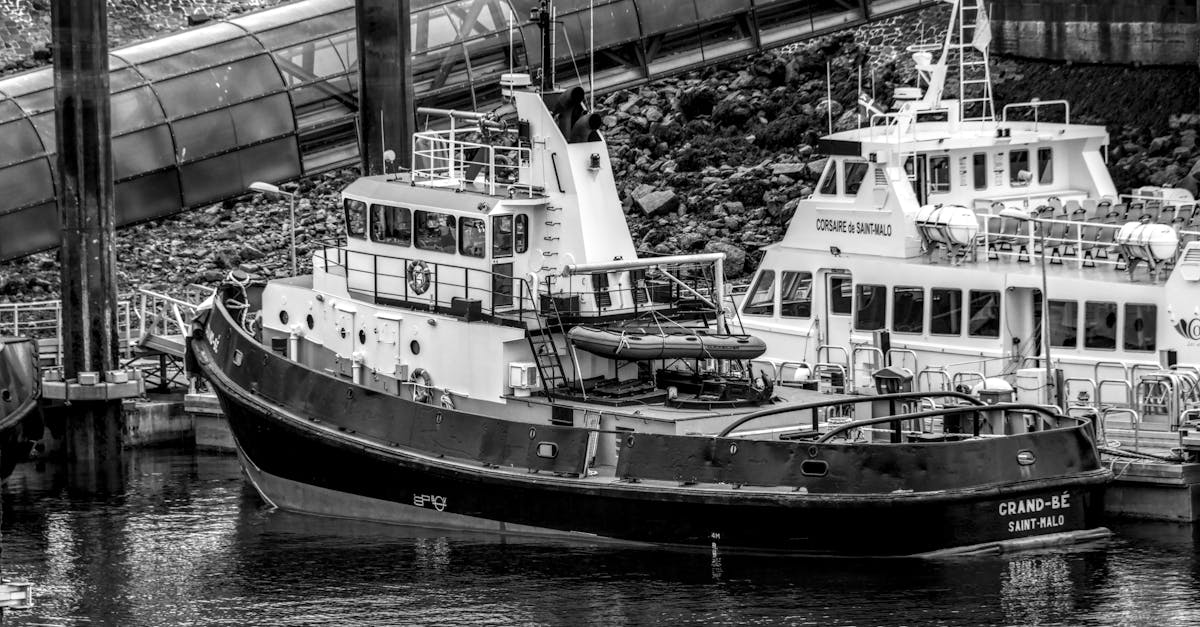 A classic black and white photo of a tugboat docked in Saint-Malo harbor.