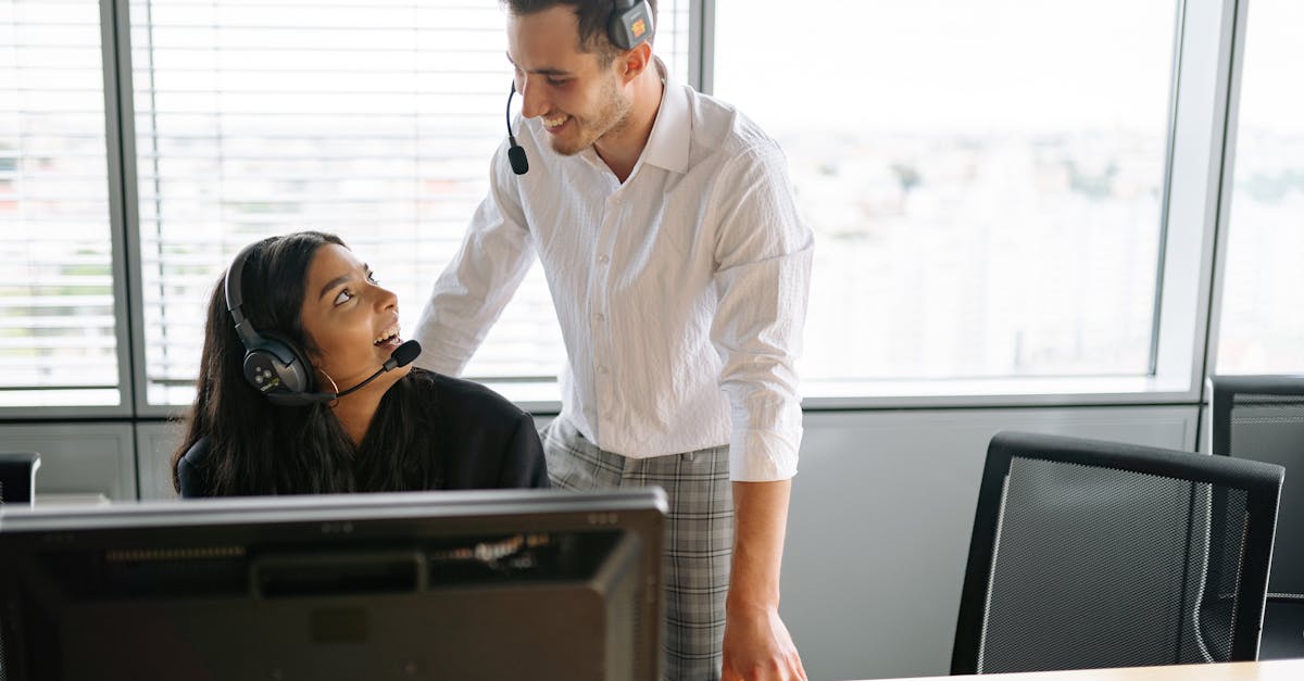 Smiling colleagues wearing headsets working together at a call center in a modern office setting.