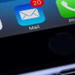 A close-up photo of a smartphone displaying popular apps like Google and Mail.