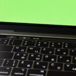 Russian keyboard MacBook Pro with a green screen. Modern electronic device.