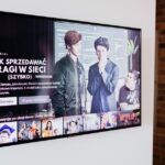 Smart TV displaying streaming content in modern living room setting with exposed brick wall.