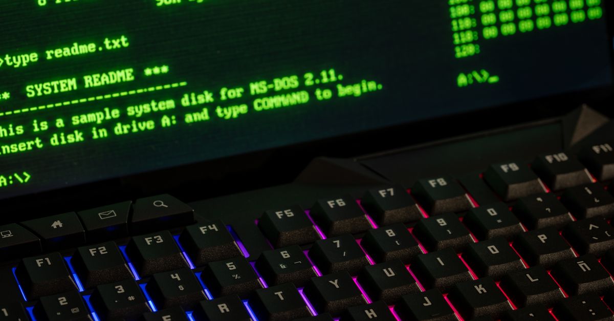 Close-up of a retro computer screen displaying MS-DOS commands with a vibrant keyboard.