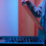 A man carefully fits a glass panel onto a gaming PC while adjusting internal cables.