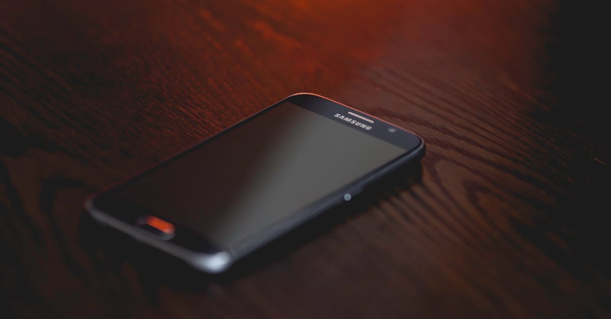Close-up of a smartphone placed on a dark wooden surface, creating a moody tech ambiance.