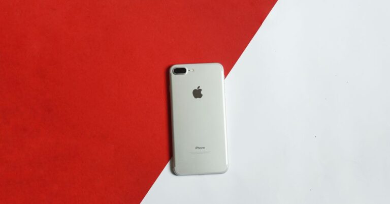 A silver smartphone placed on a contrasting red and white background captured from above.