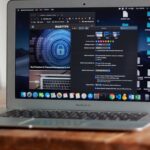 Open MacBook Air with apps and web browser on screen, placed on a wooden table indoors.